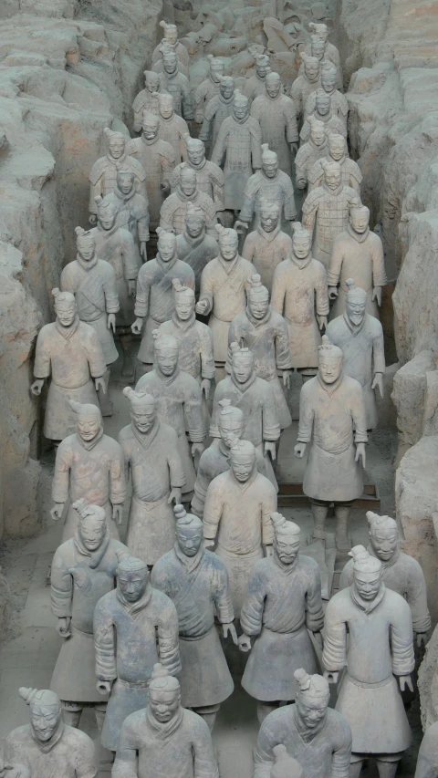 the many statues are displayed together in a long row
