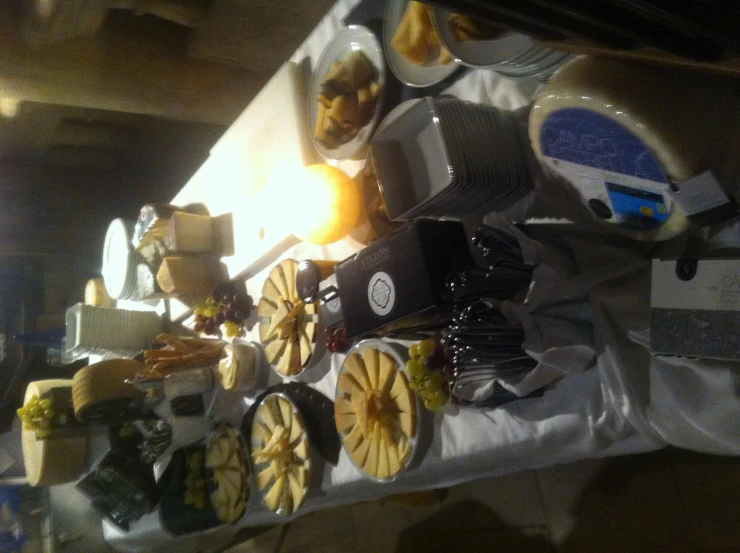 several different plates and containers with food and candles sitting on the table