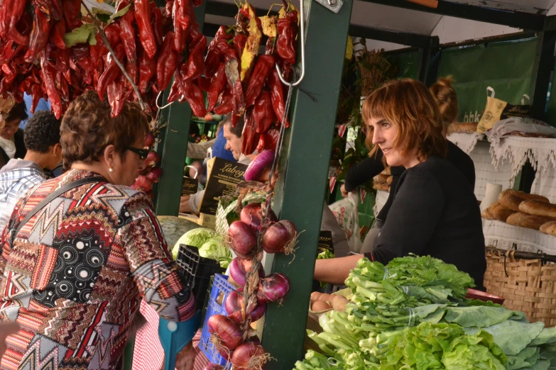 a woman is shopping for vegetables in an outdoor market