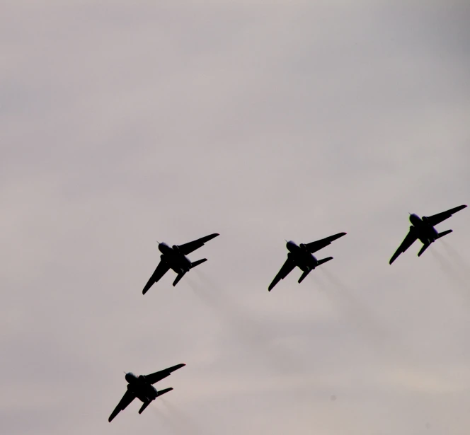 four jets are flying in formation on a clear day