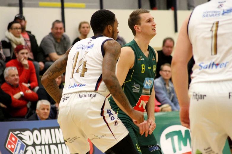 a basketball player holding a ball near two other players