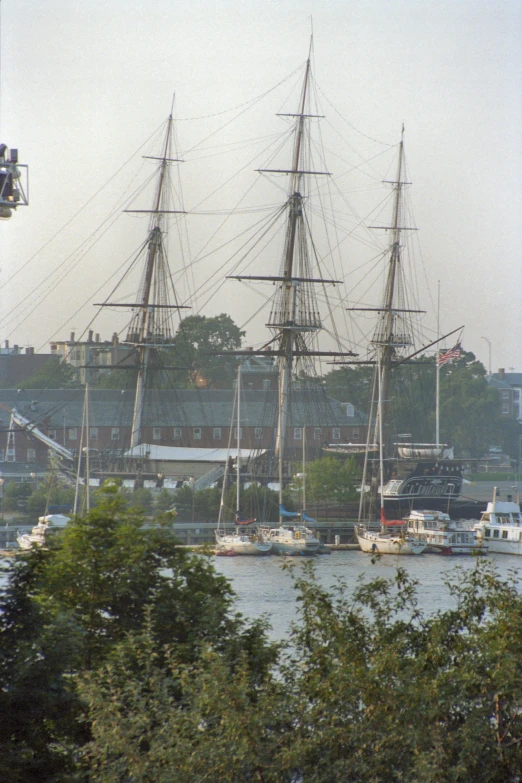 two tall boats in the water with a building behind them