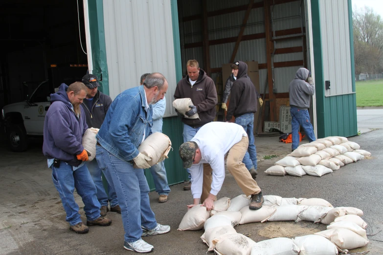 several men working with sandbags at a warehouse