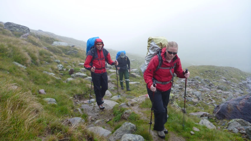 two hikers hiking up a mountain pass with back packs