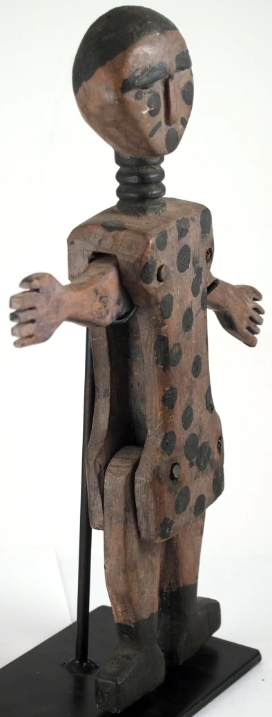 a wooden toy figure with hand on leg