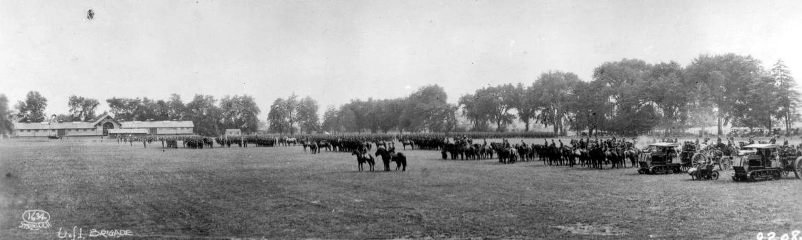 a group of men standing around a field on horses