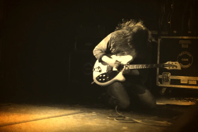 a black and white pograph of an electric guitar player