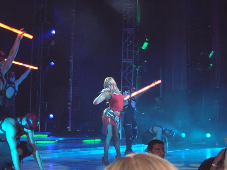 a woman performing on stage during a performance with other people