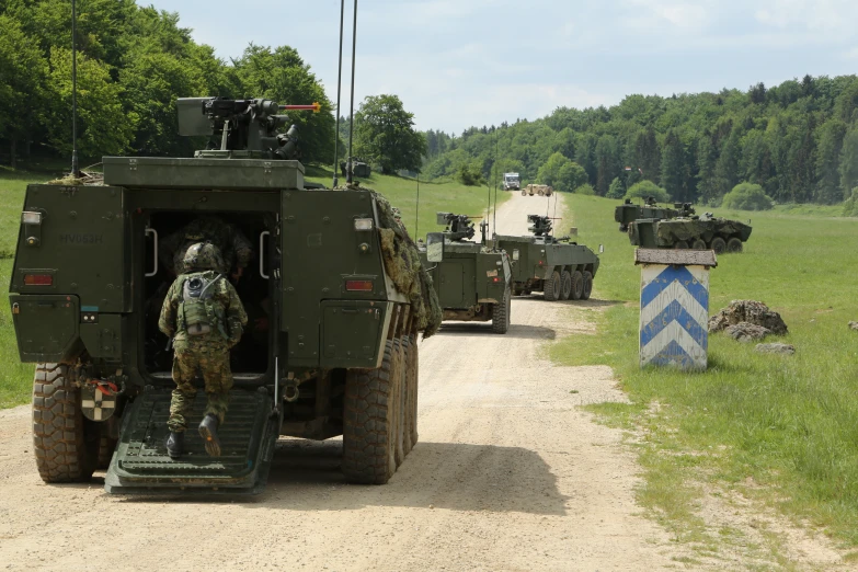 two men in army fatigues climbing out of a large vehicle