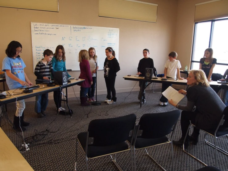 adults talking in a class classroom in front of bulletin board