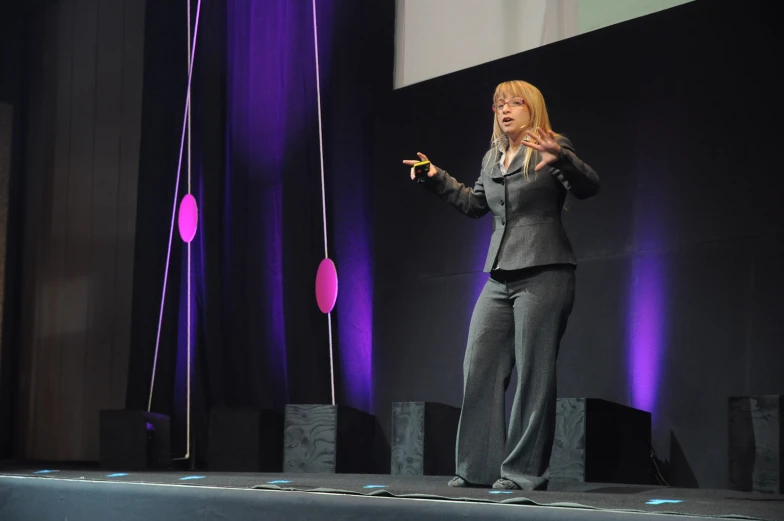 a woman with a black jacket on speaking into microphone