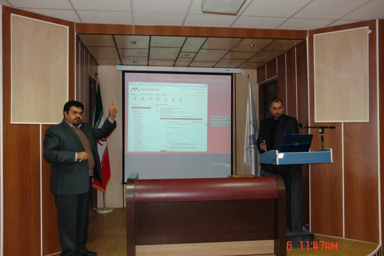 two people are standing near a presentation screen