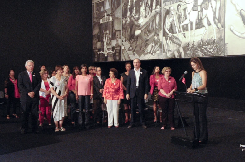 a man and women in pink are standing with microphones