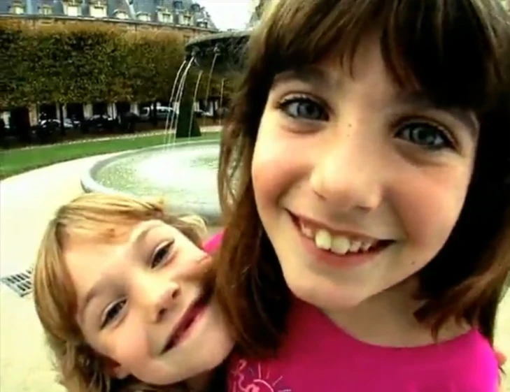 two s posing for a po in front of a water fountain