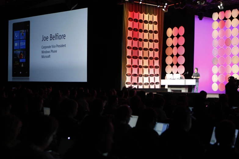 person standing on stage giving presentation to an audience