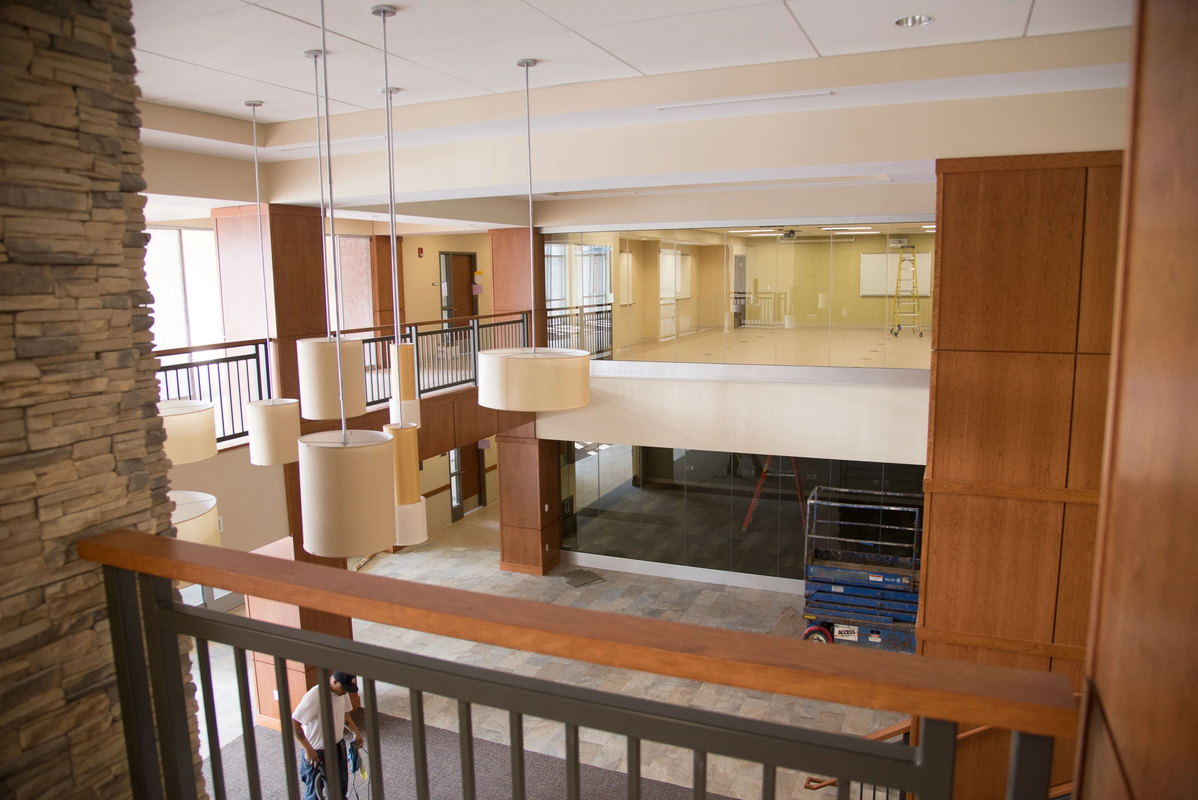 an empty room with a railing and some hanging lamp