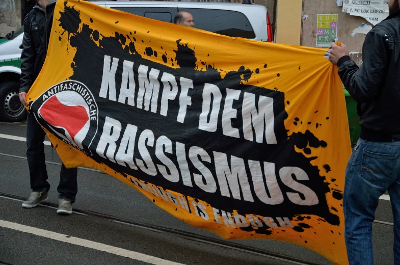 the banner in front of a rally held by protesters on the side of the road