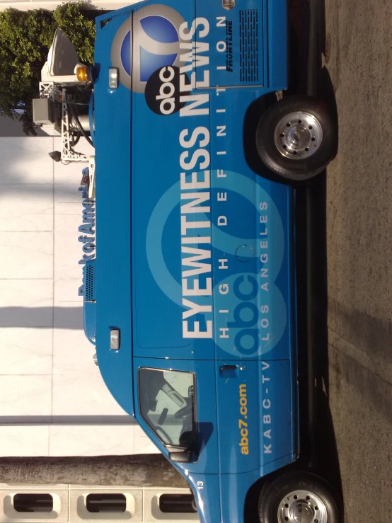 a blue bus parked next to a white car