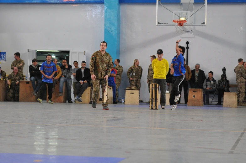 several soldiers stand in a line near a basket ball net