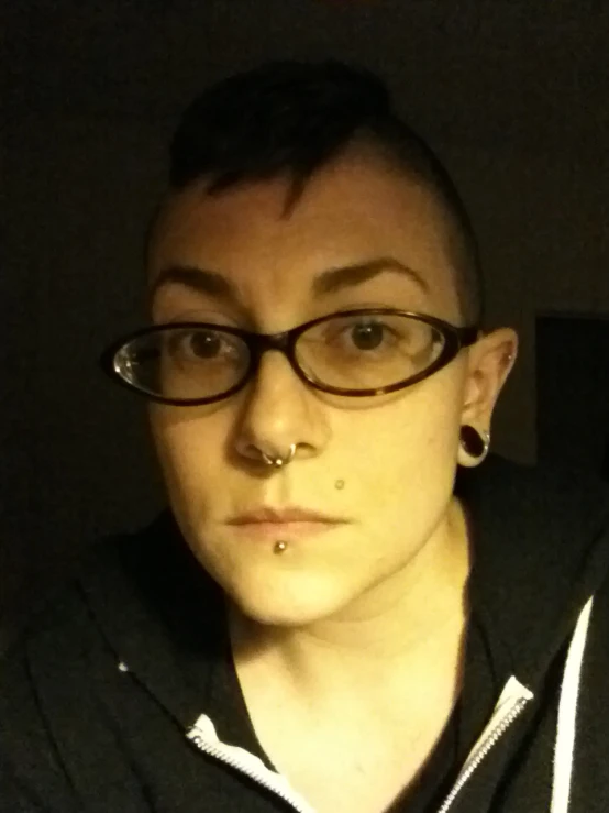 a woman wearing a black sweater and a nose piercing