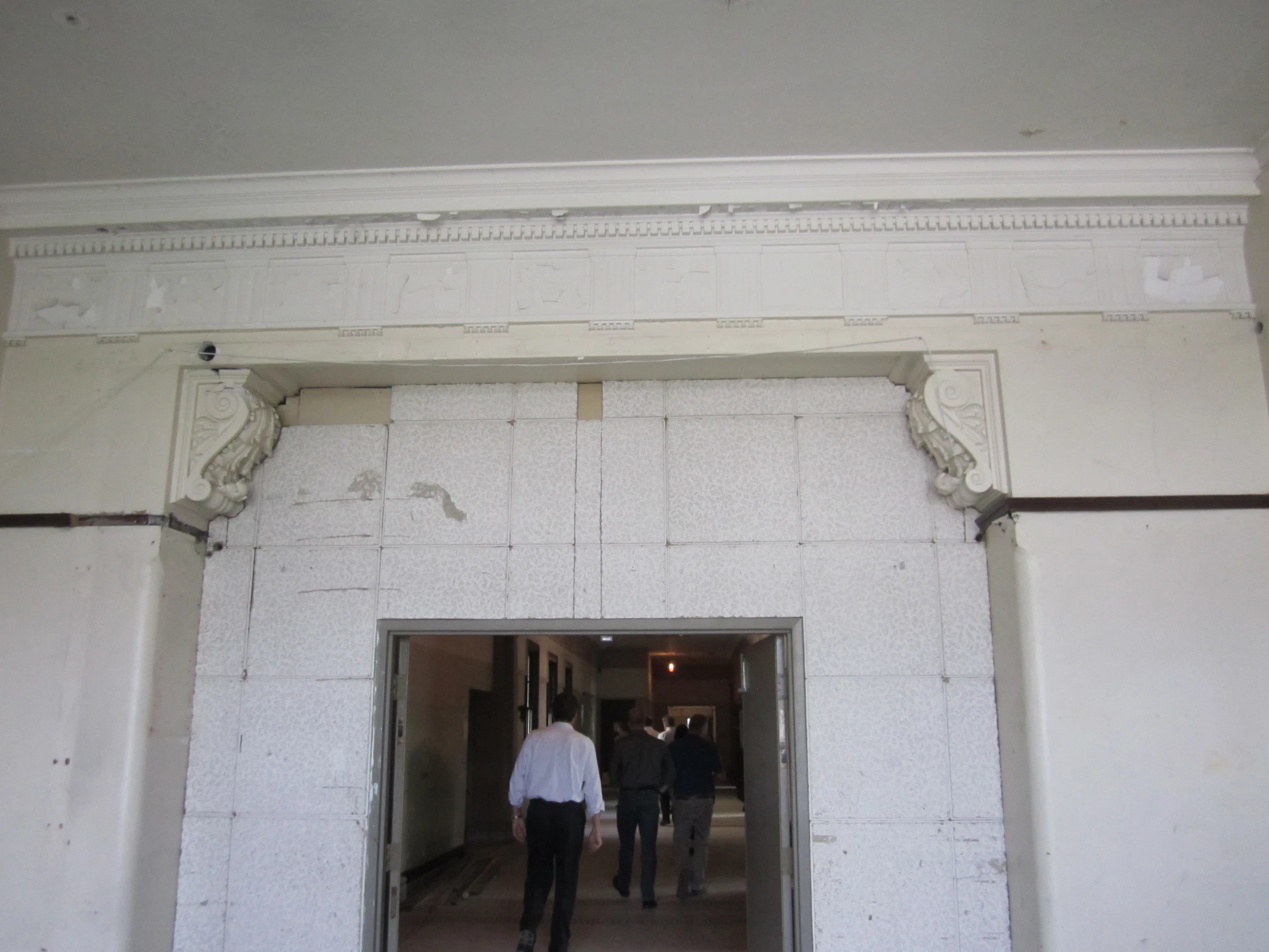 two men walk towards the entrance to a building