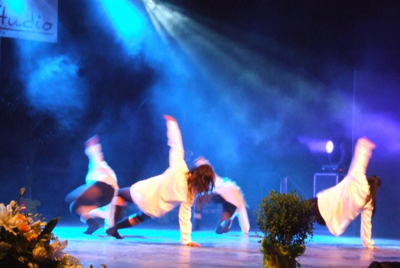 four dancers performing a show on stage at the same time