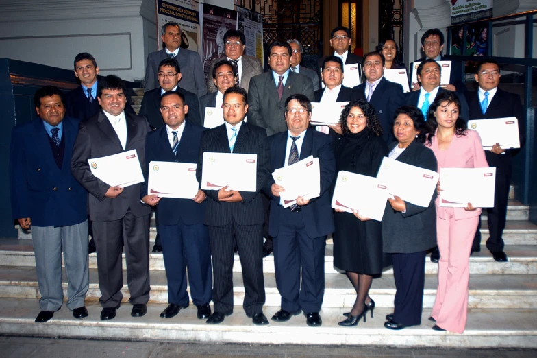 business people pose with their work cards on the steps