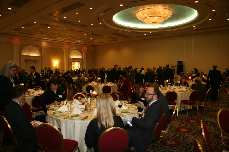 many people are sitting around small tables eating