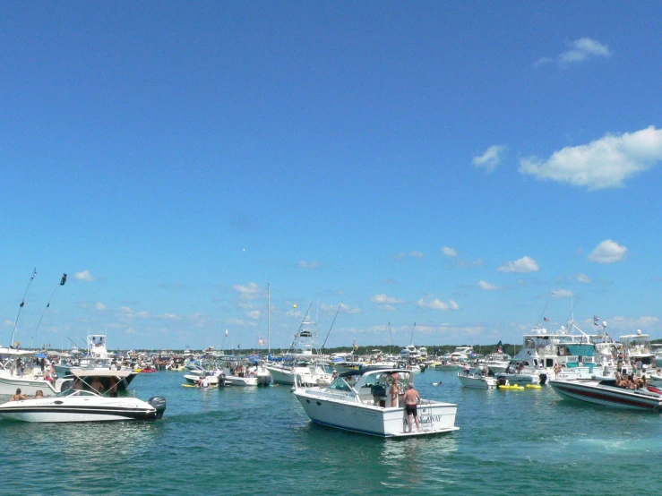 small boats and bigger boats are docked at the harbor