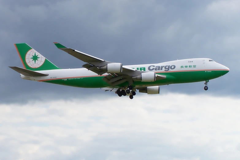 a cargo plane flying in the sky with it's landing gear down