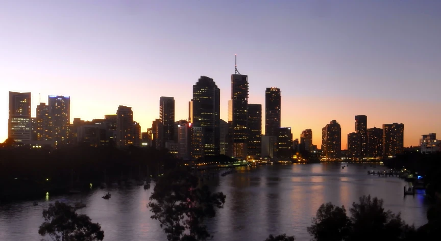 a cityscape at sunset, as seen from across the water