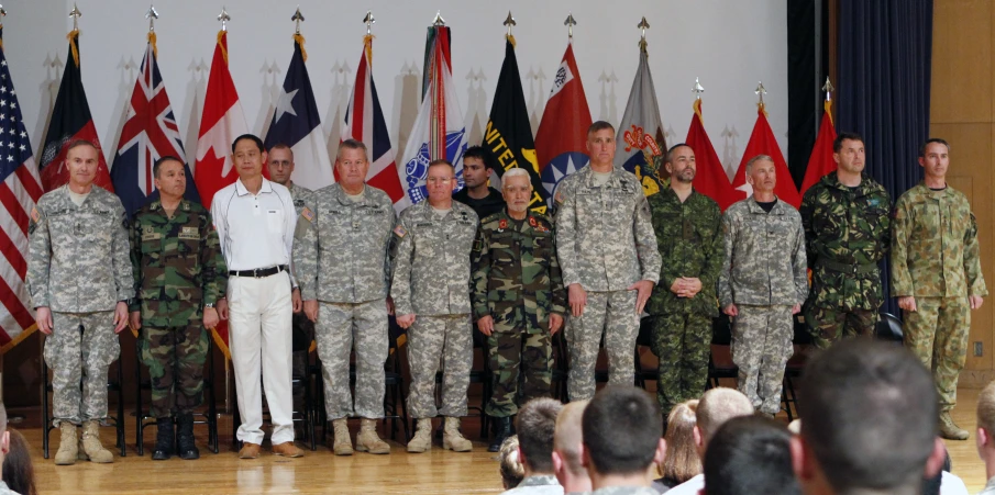 group po in military clothes standing by a flag wall