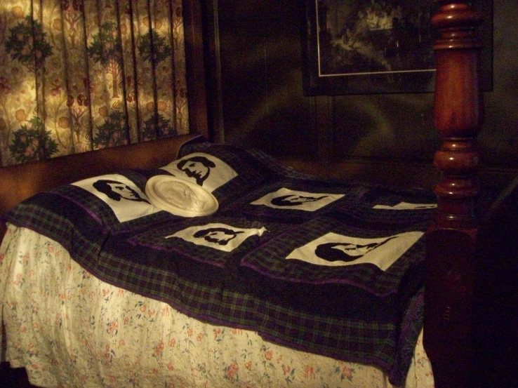 a bed with a pillow, quilt and picture on it