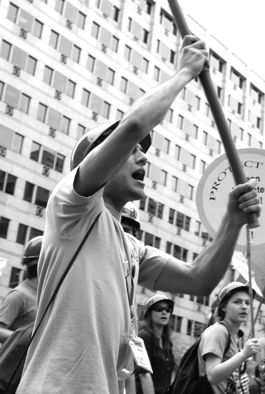 a protest with a sign held up in the air and a man holding up the protest sign