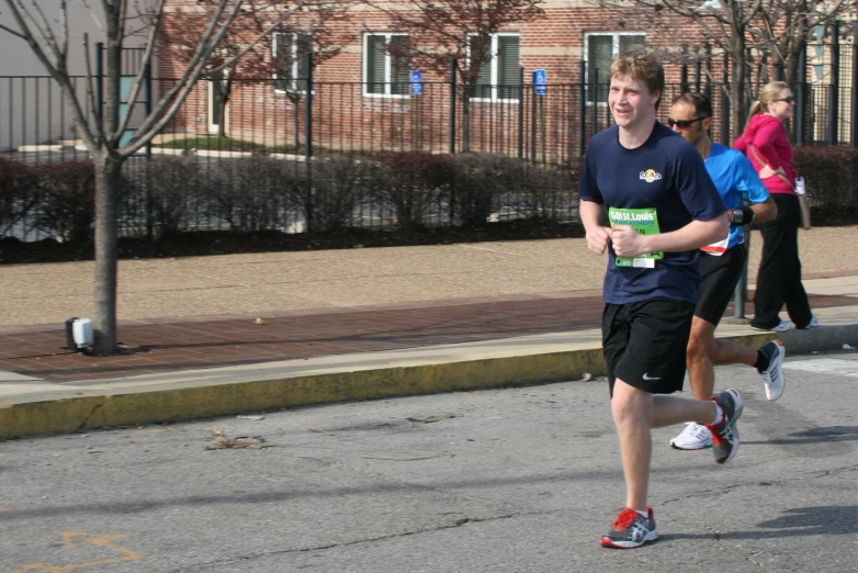 a man running in a race wearing an adidas t - shirt