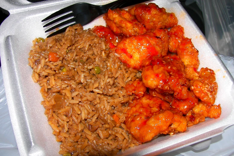a white plastic tray filled with rice and chicken