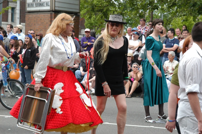 two woman dressed in costume walking through a street