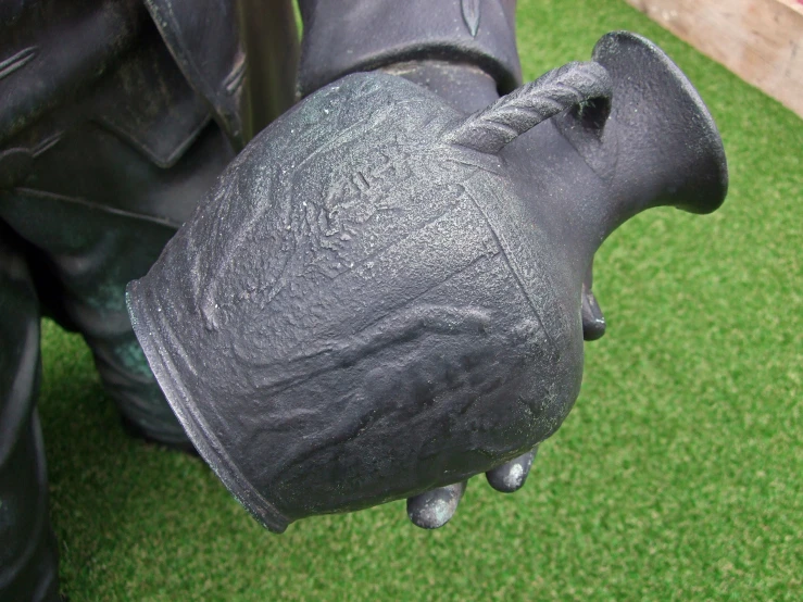 an iron sculpture has a black coat over the outer of its head