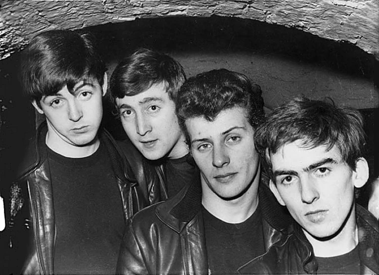 four men standing together under an arched window