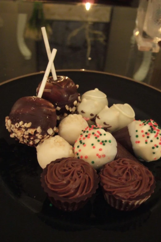 several small cookies and candys on a black plate