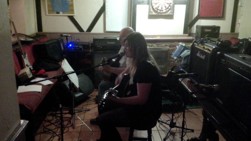 two people sitting in front of a guitar and keyboard