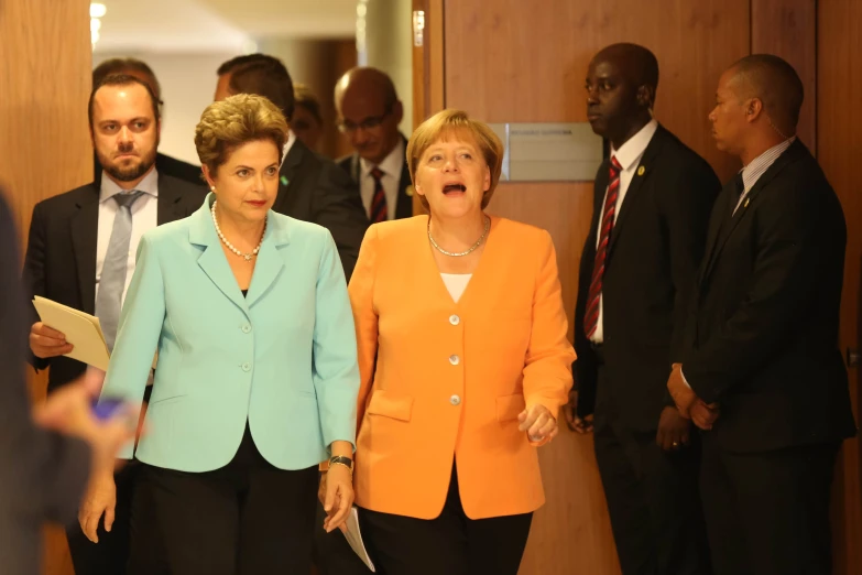 three women, two wearing suits and one in a suit