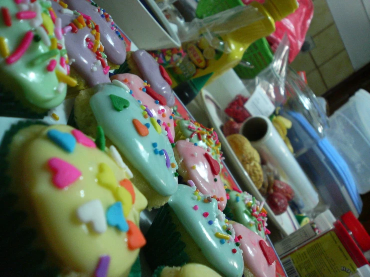 a display of various decorated donuts in plastic cases