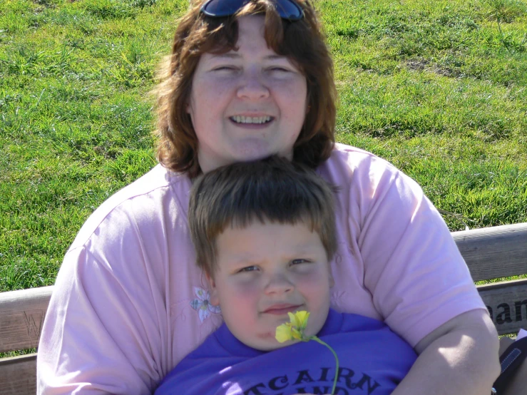 a woman sitting with her son at the park