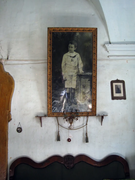 antique portrait hangs on white wall in historic room