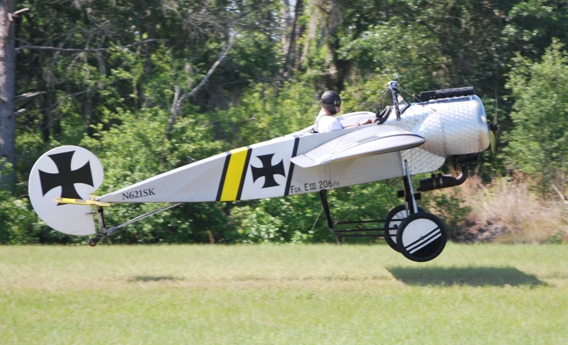 a white and black airplane flying through a forest