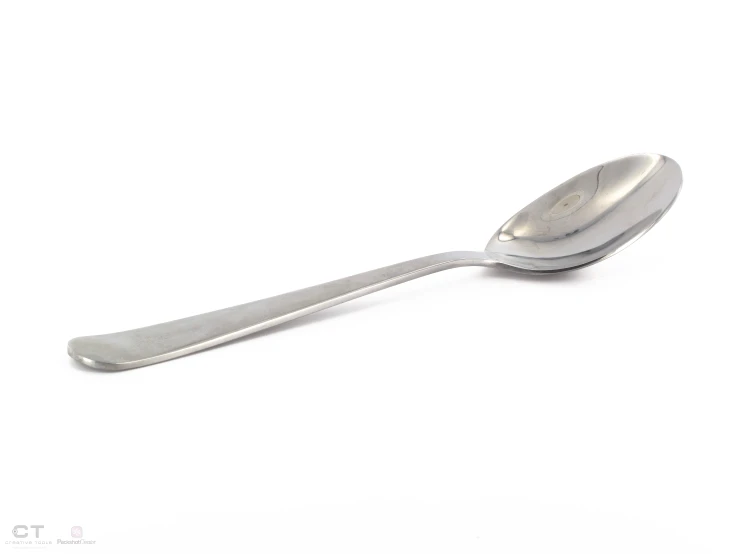 a spoon sitting on a white surface, with the spoon extended up