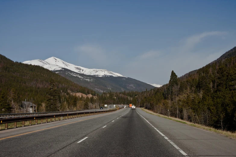 the mountains and trees are next to the road