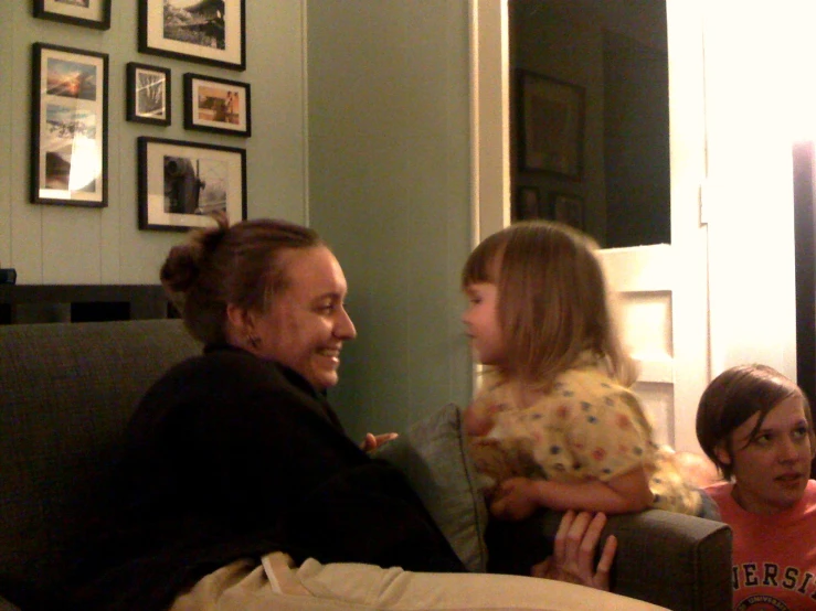a little girl is in her mothers lap and talking to the woman