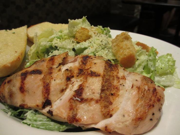 a dinner plate with some bread and a chicken 